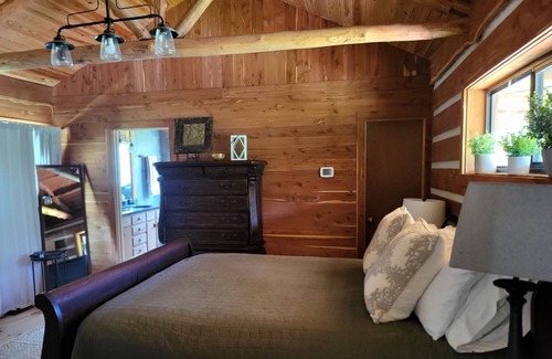 New Ulm Cabin | Cedar Acres offers a 3 Bedroom Log Cabin that overlooks a pond.