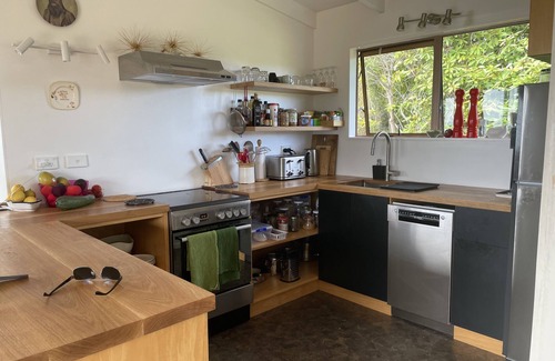 Orua Bay House | La Cachette is a charming Kiwi bach in native bush with stunning harbour views.