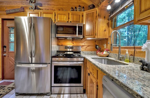 McCaysville Cabin | Nestled by the babbling creek, Creekside Hideaway warmly welcomes pets, offering a hot tub, over-sized screened porch with TV, firepit, and WiFi