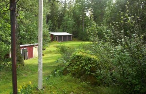 Vissefjaerda House | Red and white cottage with a boat not far from the lake