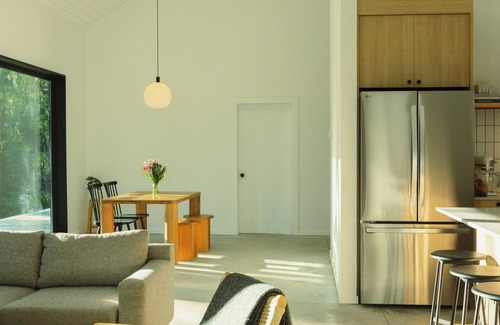 Garden Bay House | Scandinavian-inspired black cabin with cedar hot tub in a private forest.
