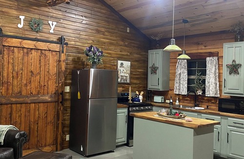 Tishomingo Cabin | The Cozy Pines is a newly built, romantic log cabin with a 2-sided fireplace.