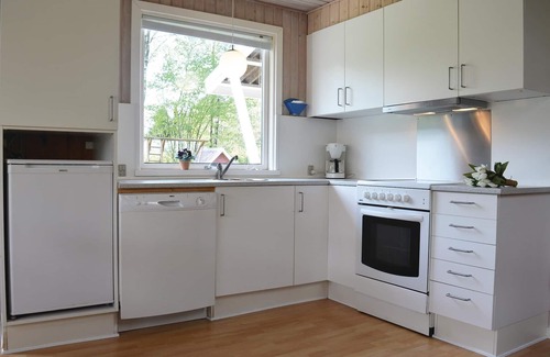 Skovgaarde House | This cozy cottage is family friendly furnished with kitchen and living room with fireplace in open c