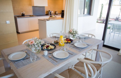 Vila Nova De Cacela Apartment | Unwind on the shaded terrace overlooking the lush gardens and pool.
