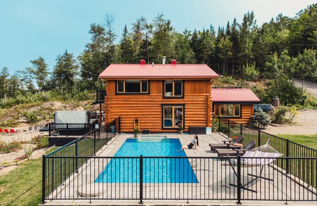 Charming log cabin nestled in the woods, with a spa and in-ground pool.