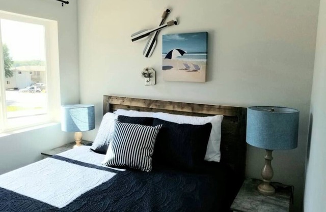 Cozy 2-bedroom suite with full kitchen, living room (couch, 2 chairs), dining table (2 stools), smart TV with cable. Perfect for short or long stays.