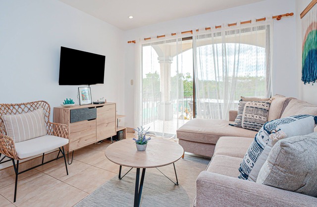 Modern condo near beaches with mountain views, outdoor pool, balcony, W/D, AC