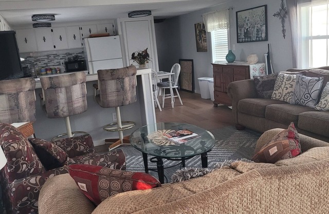 Spacious mobile home with large kitchen/living area and porch with barbeque.