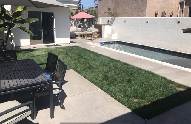 Spanish bungalow with pool, built in bbq, and outdoor seating areas.