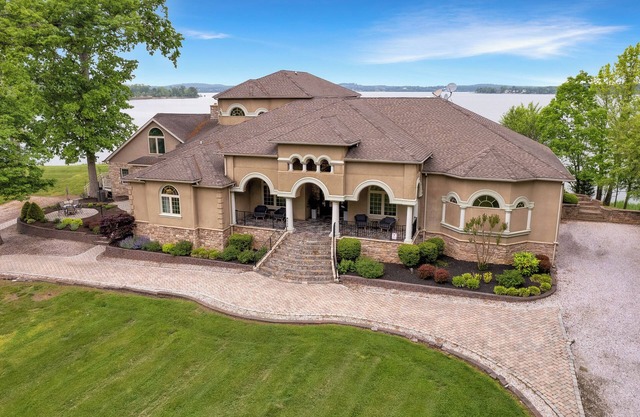 Stunning waterfront villa with indoor pool and kids swing set and play area.