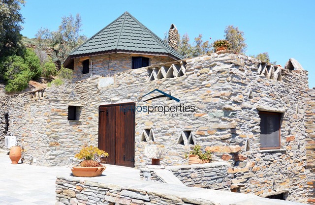 Traditional stone built villa with a windmill and a swimming pool in Koundouros