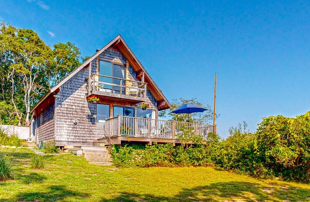 Water-view home with large deck, balcony, enclosed sunroom & peaceful location