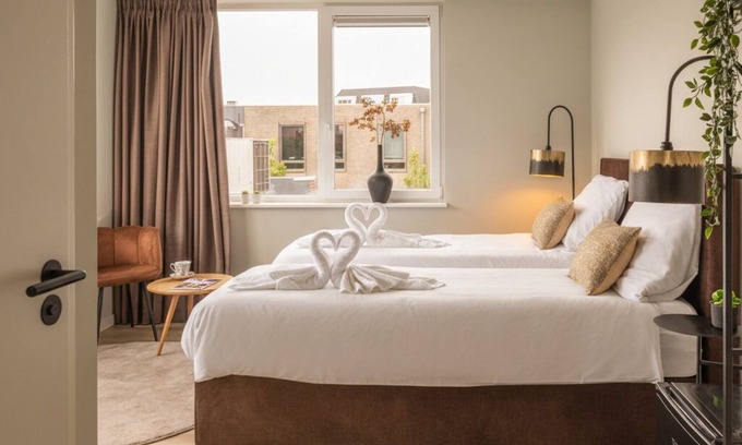 Raamsdonksveer Apartment | Enjoy a stylish room designed for both relaxation and productivity. Sleep soundly on a luxurious box-spring bed (twin or double setup), work or dine comfortably at your table, and stay cool with air conditioning. Your private bathroom, TV, and fridge
