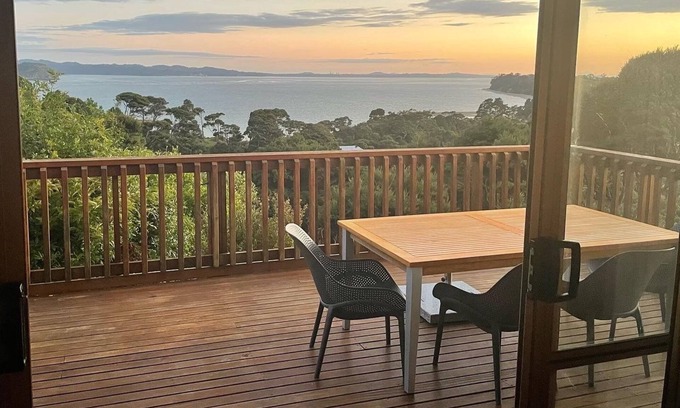 Orua Bay House | La Cachette is a charming Kiwi bach in native bush with stunning harbour views.