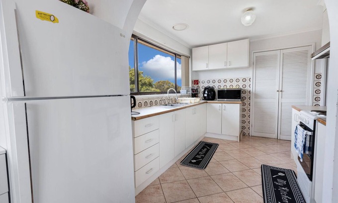 Lakes Entrance House | Perched on a slope, this retreat offers views of the ocean in the distance